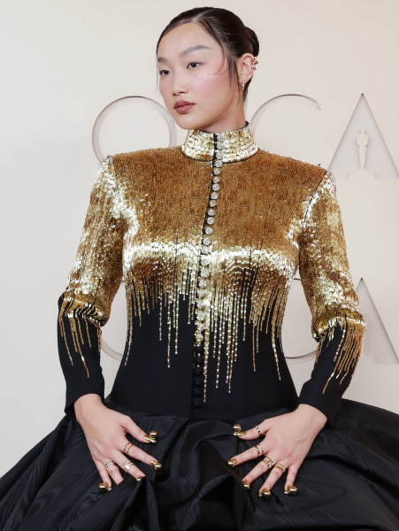 Audrey Nuna posing in a gold and black dress